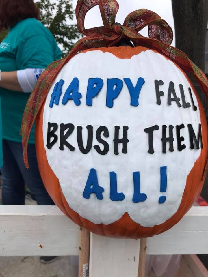 A carved pumpkin reading Happy Fall, Brush Them All