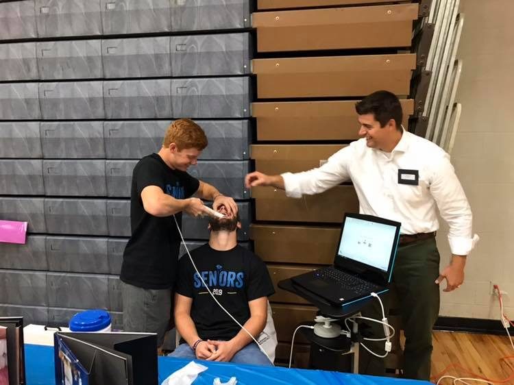 Dr. Dunwell showing dental technology to a young visitor
